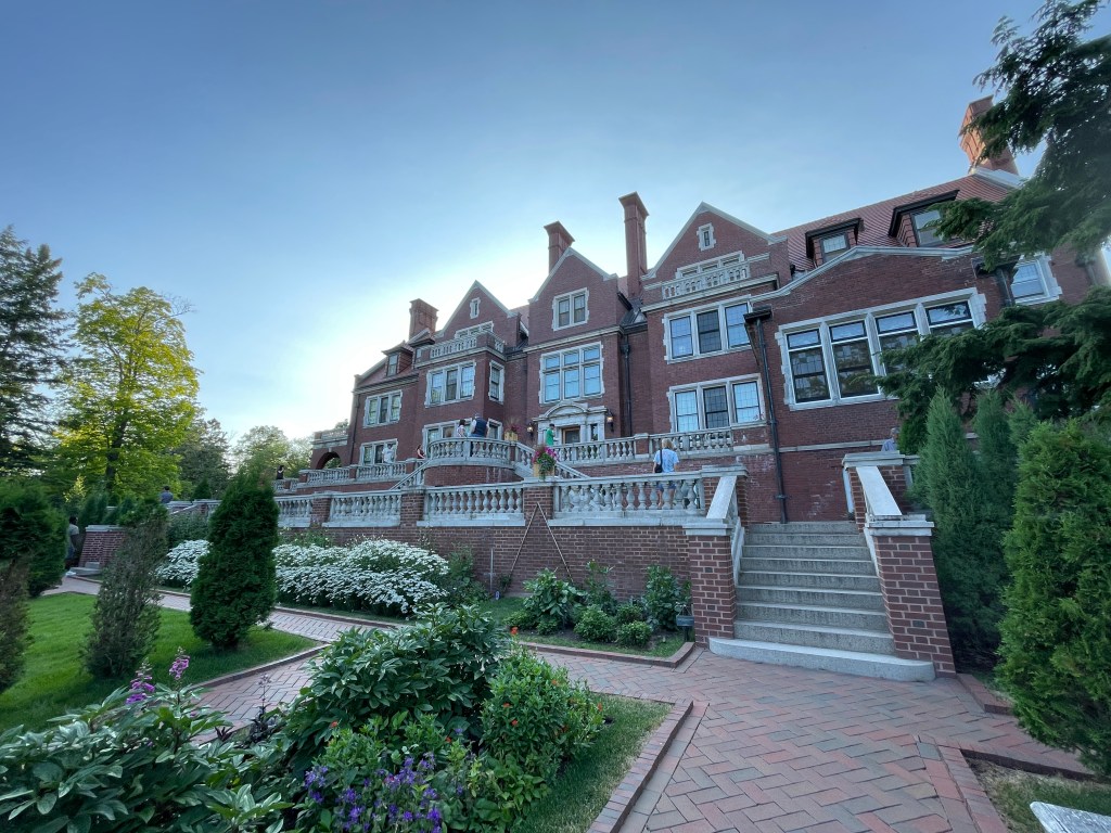 A view of the Glensheen mansion. It features red brick and a neo-classical architectural style.