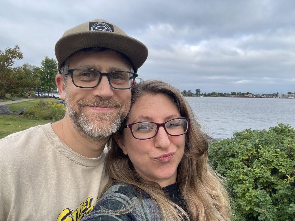 Yahm and Adam selfie with a view of the lake in the background