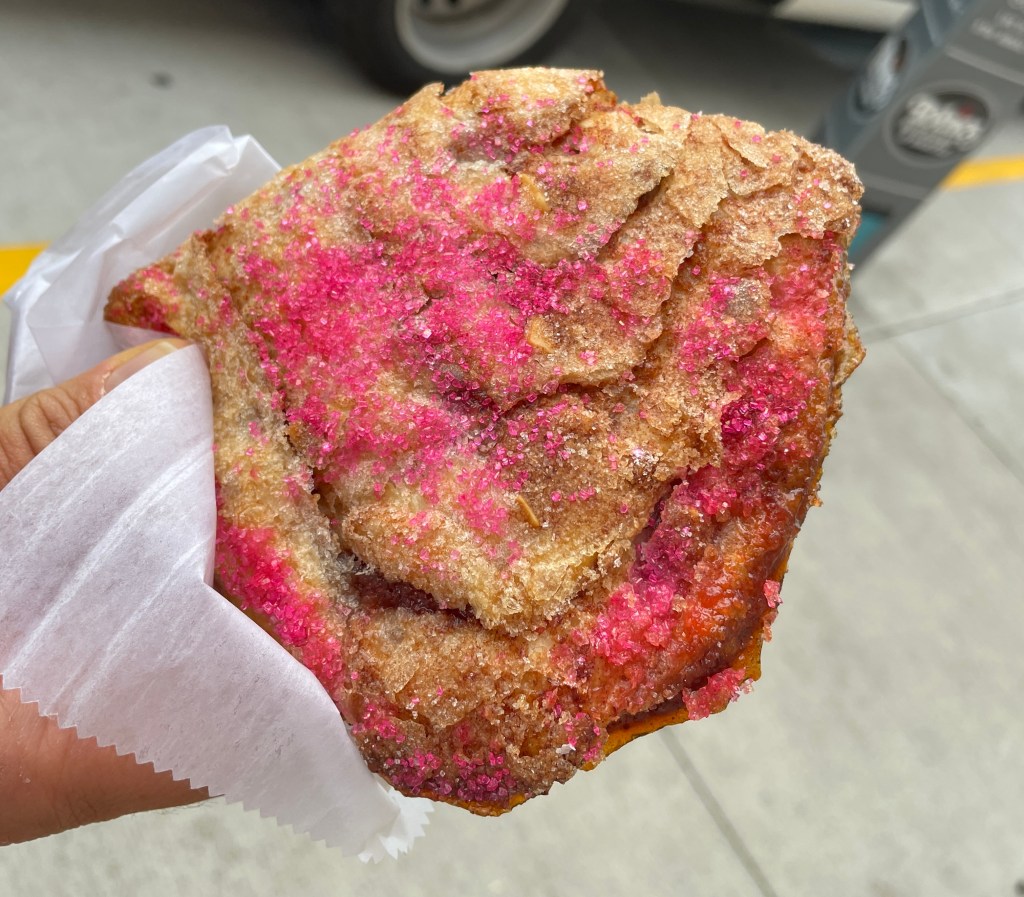 Close-up of a rhubarb crispy: a rhubarb-filled pastry with bright pink sugar on the outside