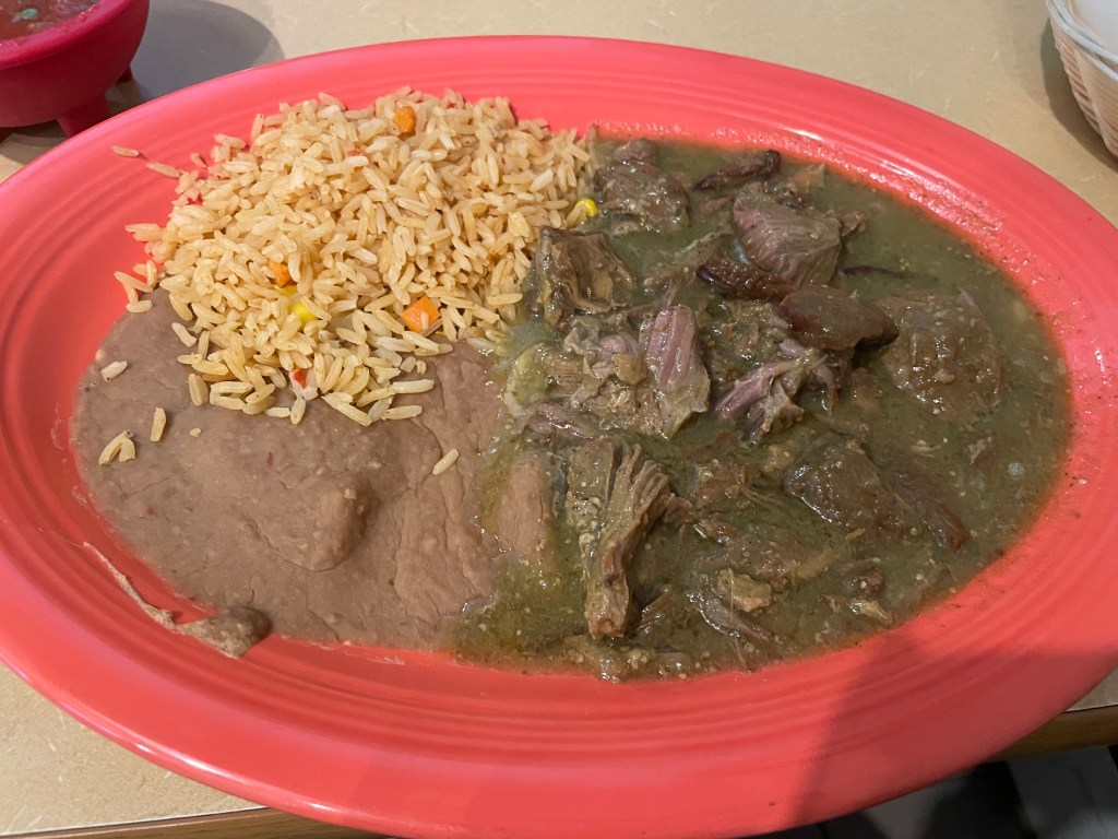 Pork chile verde with refried beans and rice